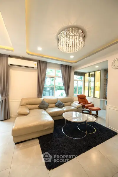 Luxurious living room with elegant chandelier and modern leather furniture