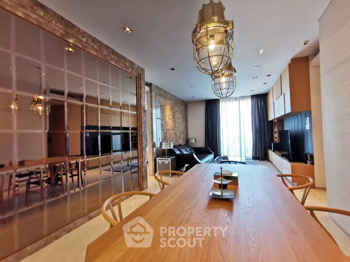 Spacious modern living room with elegant dining area and stylish lighting fixtures.