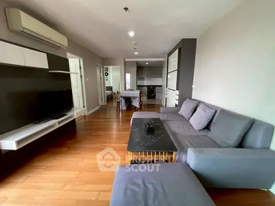 Modern living room with sleek furniture and open kitchen layout in stylish apartment.