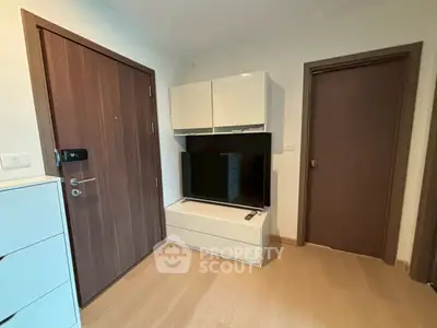 Modern apartment entrance with sleek wooden doors and stylish TV cabinet