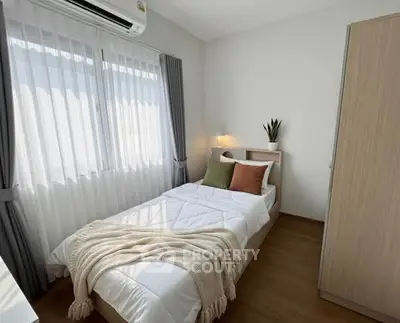 Cozy bedroom with natural light and modern decor, featuring a comfortable bed and stylish wardrobe.