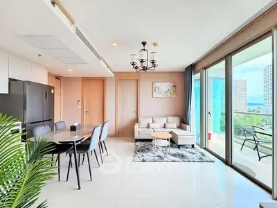 Modern living room with dining area and balcony view in a high-rise apartment.