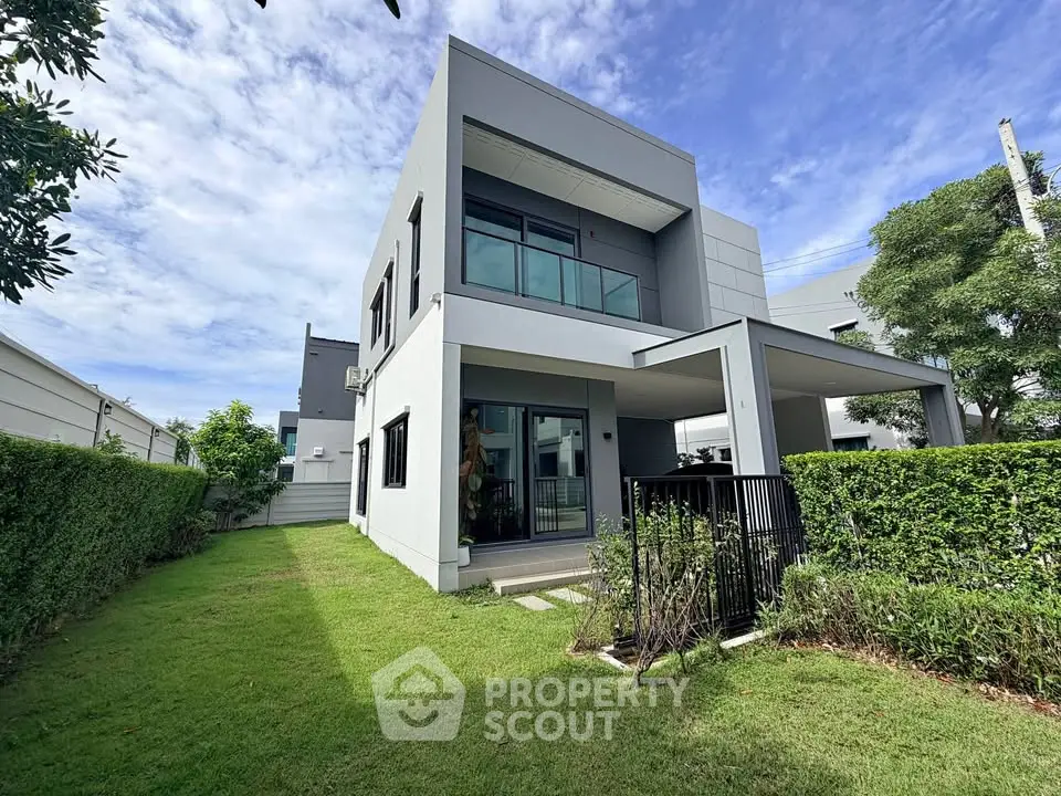 Modern two-story house with lush green lawn and contemporary design