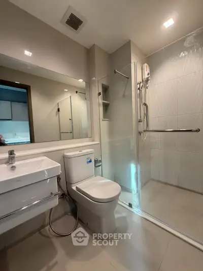 Modern bathroom with glass shower enclosure and sleek fixtures