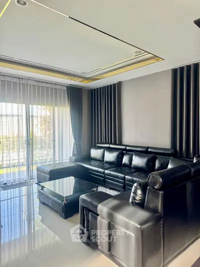 Modern living room with sleek black furniture and large windows