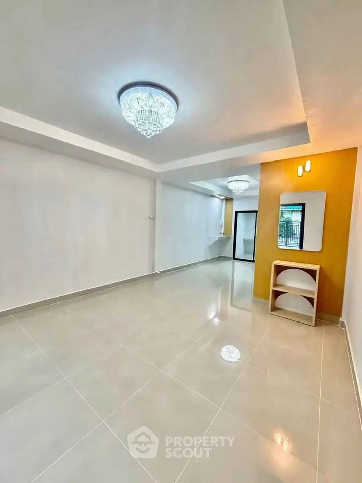 Spacious modern living room with elegant lighting and glossy tiled floors.