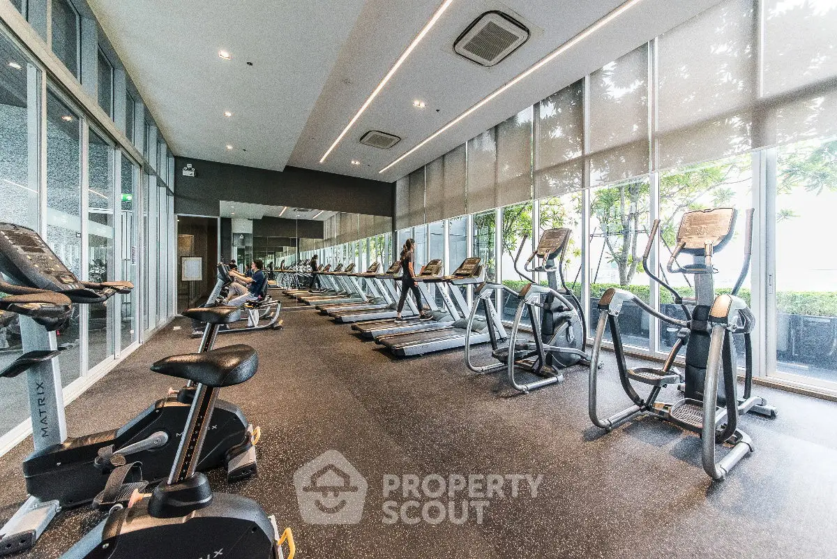 Spacious modern gym with state-of-the-art equipment and floor-to-ceiling windows.