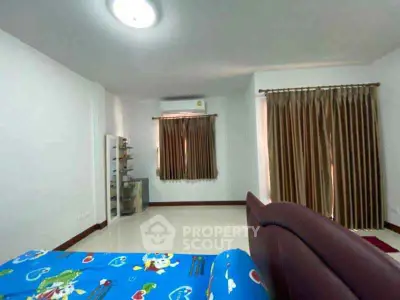 Spacious bedroom with modern decor and large windows for natural light.