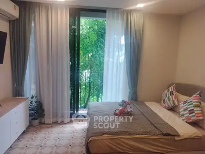 Cozy bedroom with balcony view, modern decor, and natural light