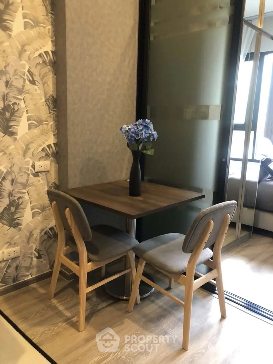 Charming dining nook with modern decor and floral centerpiece in cozy apartment setting.
