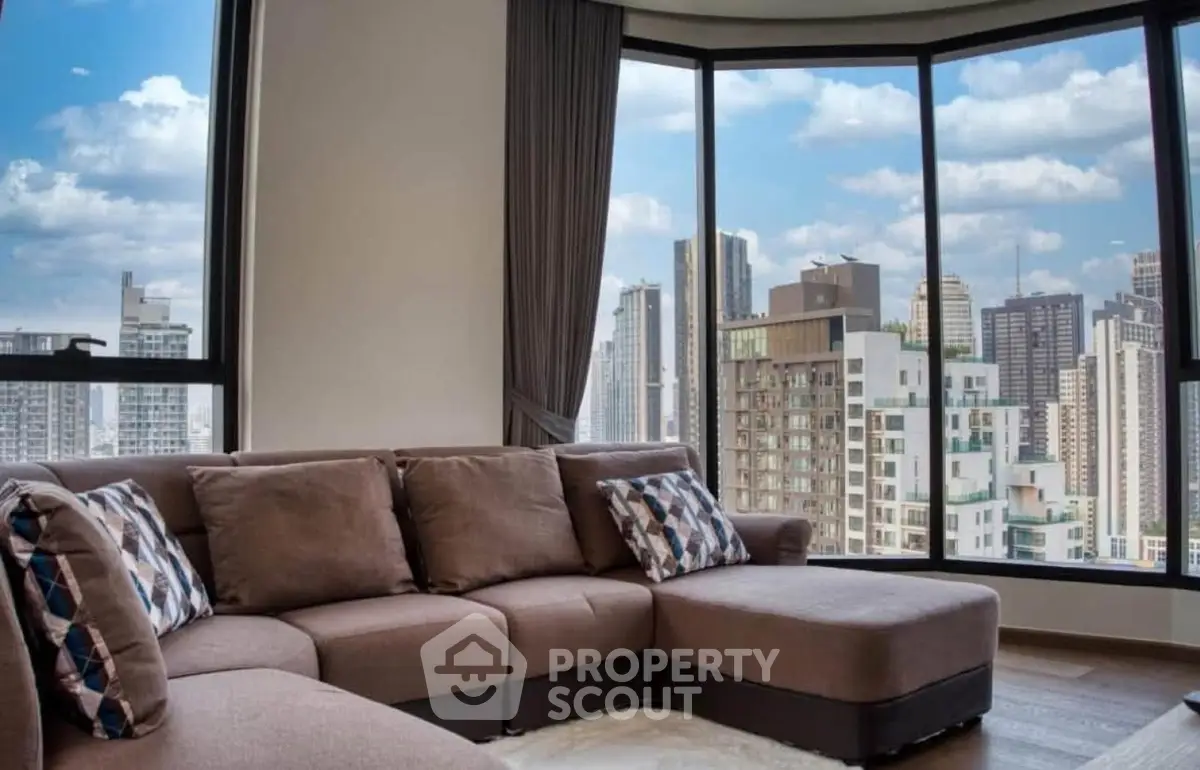 Luxurious living room with panoramic city skyline views from large windows.