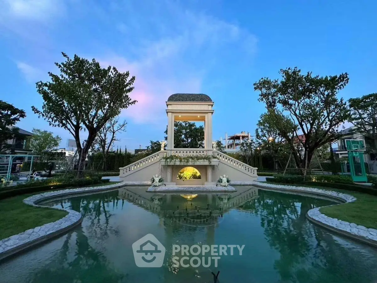 Luxurious garden with elegant water feature and lush greenery at sunset.