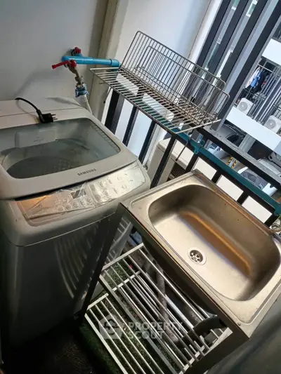 Compact balcony with washing machine and sink, ideal for urban living convenience.