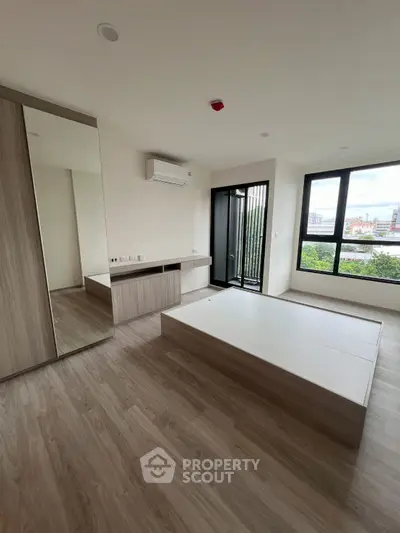 Modern bedroom with large windows and built-in storage, offering a bright and airy atmosphere.