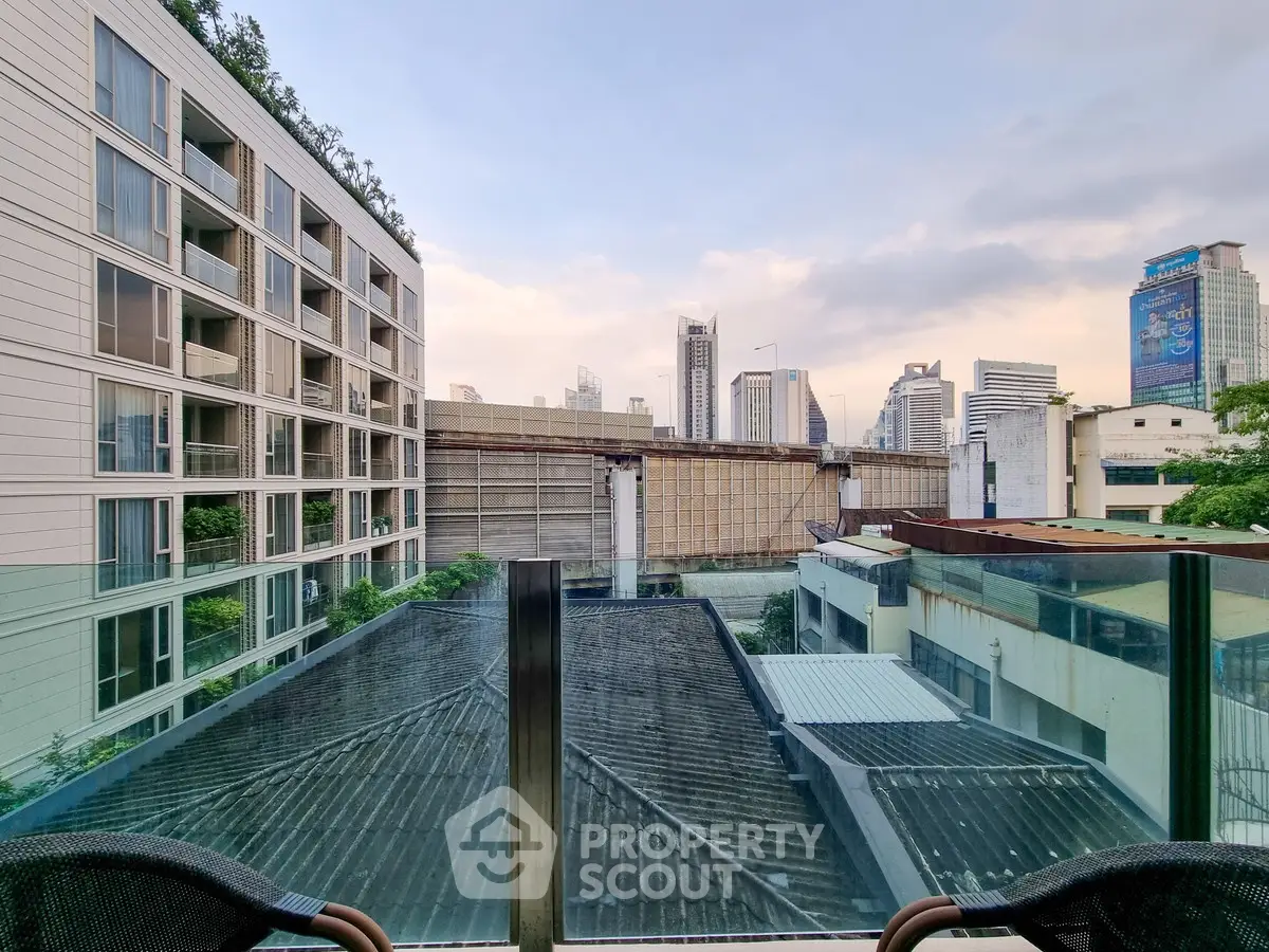 Modern urban view from a balcony overlooking city skyline and contemporary buildings.