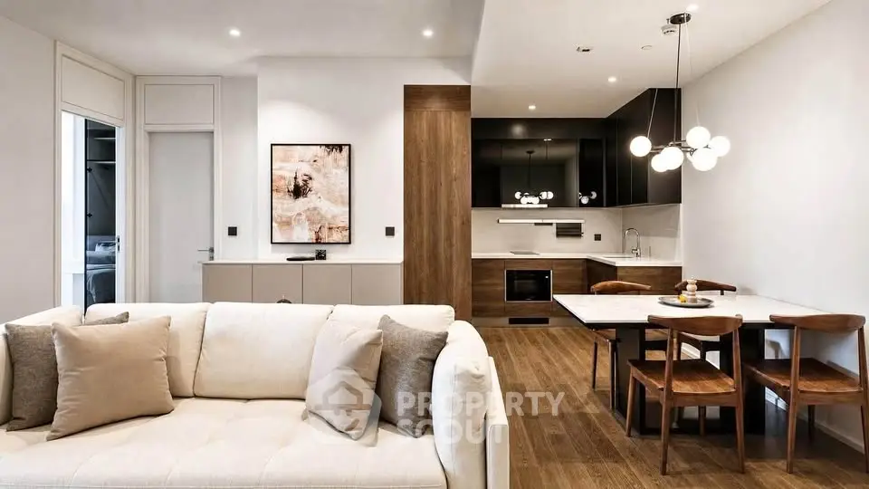Modern open-plan living room and kitchen with stylish decor and wooden flooring.