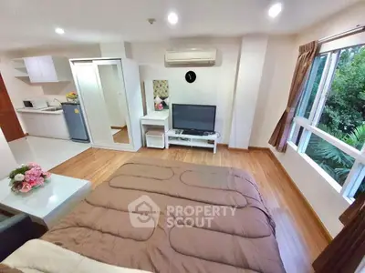 Modern studio apartment with cozy bedroom and open kitchen layout, featuring large windows and stylish decor.