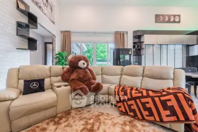 Spacious living room with plush sofa and large teddy bear, perfect for family relaxation.