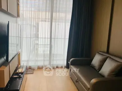 Cozy living room with modern sofa and large window with sheer curtains