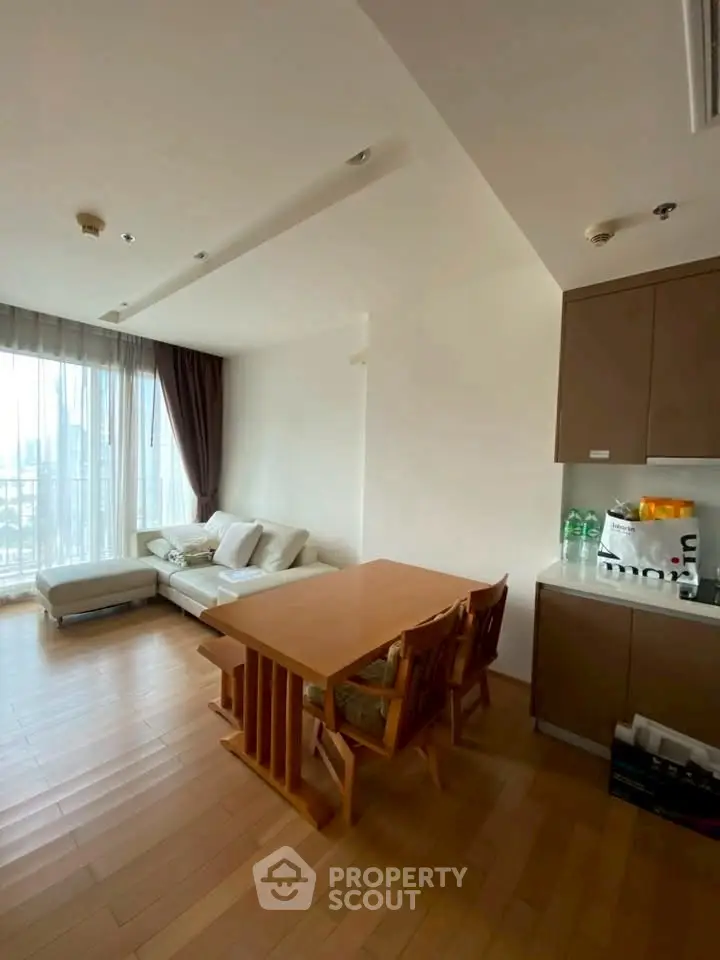 Spacious living room with dining area and large windows offering city views.