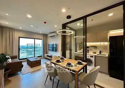 Modern open-plan living room and kitchen with stylish dining area and balcony view.