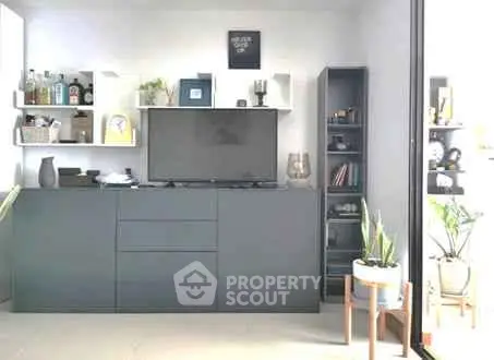 Modern living room with sleek storage and TV unit, bright and airy ambiance.