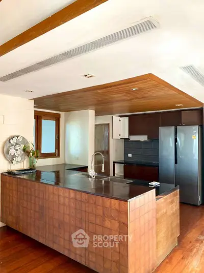 Spacious modern kitchen with sleek wooden island and stainless steel appliances