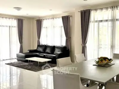 Spacious modern living room with elegant dining area and natural light.