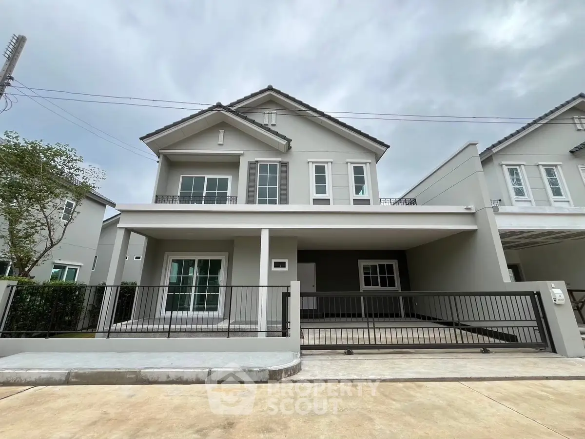 Modern two-story house with spacious driveway and sleek design.