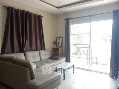 Cozy living room with modern sofa and large window opening to balcony.
