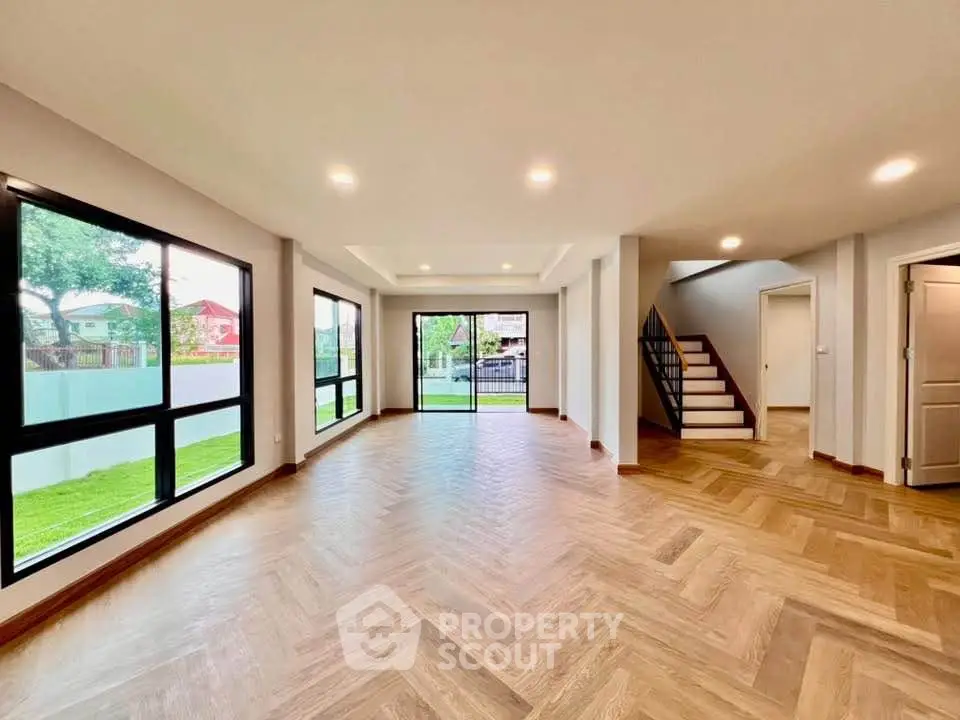Spacious modern living room with large windows and wooden flooring