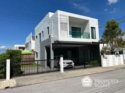 Modern two-story white house with carport and balcony in suburban neighborhood