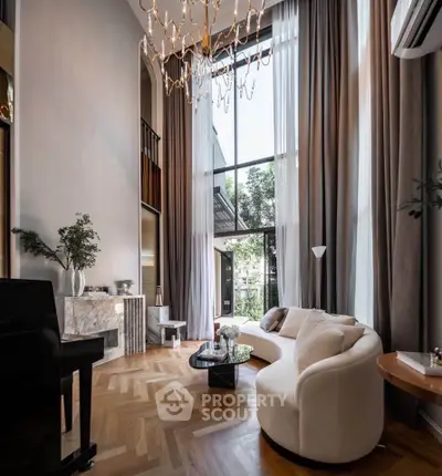 Luxurious high-ceiling living room with elegant decor and large windows.