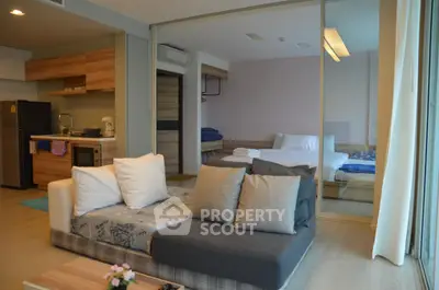 Modern open-plan living room with cozy sofa and stylish kitchen in a contemporary apartment.