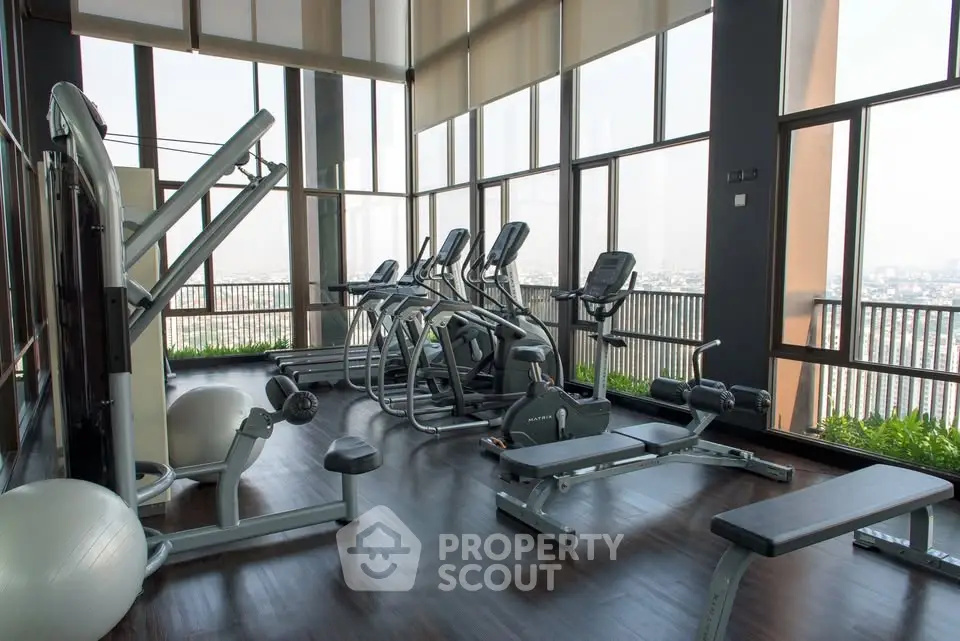 Luxurious high-rise gym with panoramic city views and modern fitness equipment.