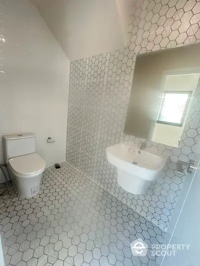 Modern bathroom with geometric tile design and sleek fixtures