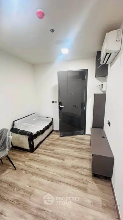 Modern compact bedroom with sleek furnishings and wooden flooring, ideal for urban living.