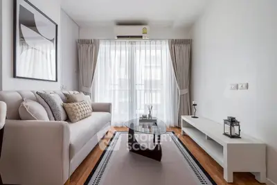 Modern living room with elegant decor, featuring a cozy sofa, stylish coffee table, and large window with curtains.