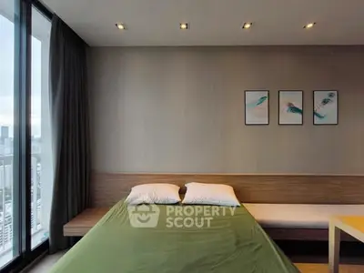Modern bedroom with city view, featuring stylish decor and large windows for natural light.