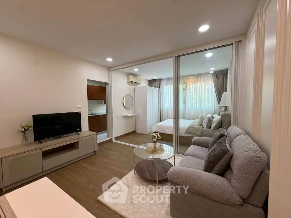 Modern open-plan living room with cozy seating and stylish decor in a contemporary apartment.