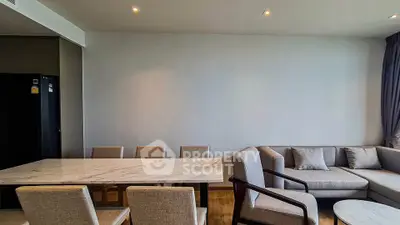 Modern living room with elegant marble dining table and cozy seating area.