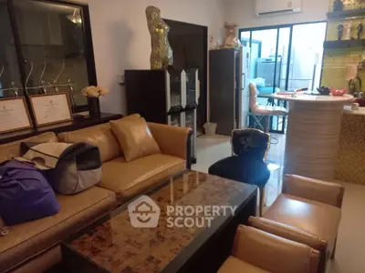 Stylish living room with modern decor and open kitchen layout, featuring elegant furniture and unique design elements.