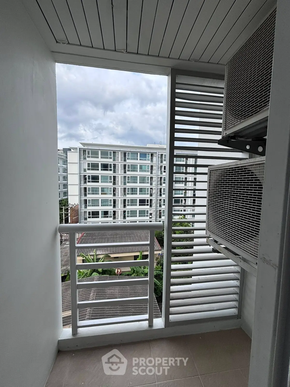 Compact balcony with city view and air conditioning units, perfect for urban living.