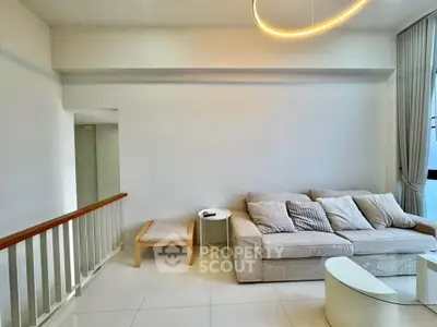 Modern living room with cozy sofa and elegant lighting in a bright, minimalist space.