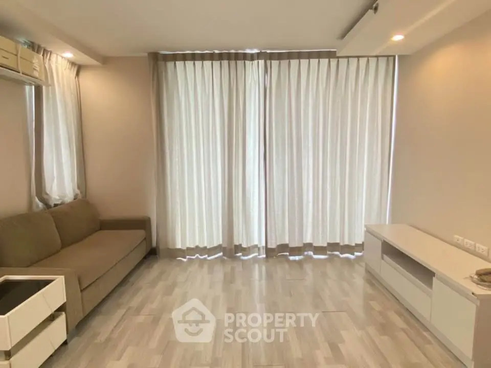 Spacious living room with modern decor and large windows in a stylish apartment.