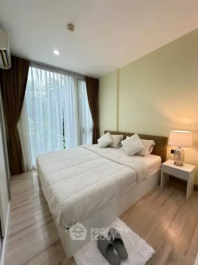 Cozy bedroom with modern decor, large window, and soft lighting for a serene ambiance.