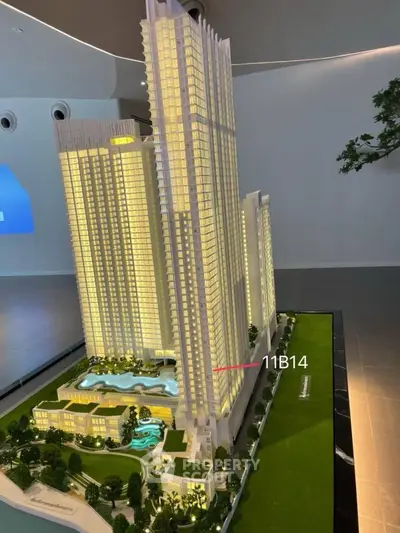 Stunning architectural model of a modern high-rise building with illuminated windows and landscaped surroundings.