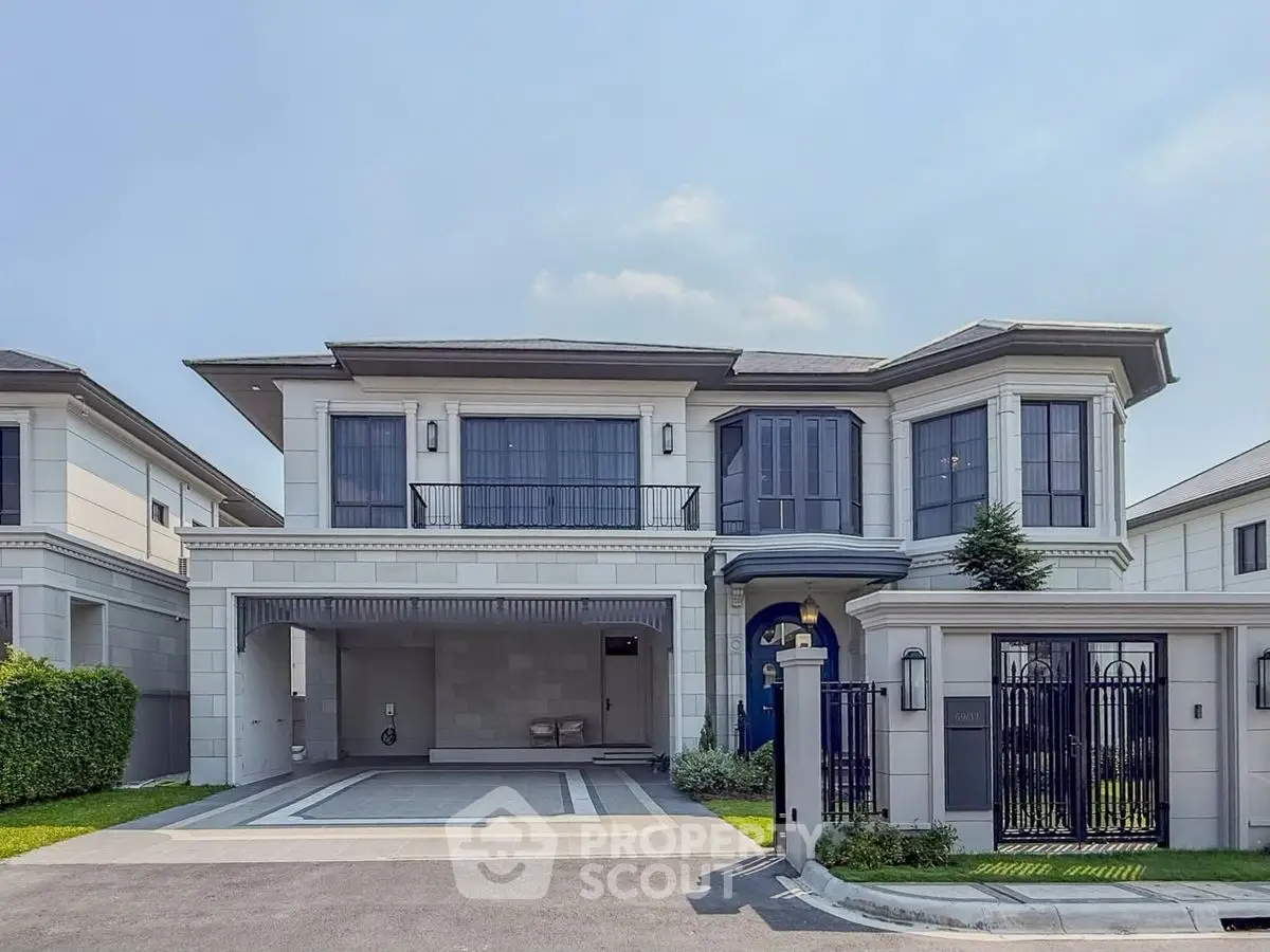 Luxurious modern two-story house with elegant facade and spacious driveway.