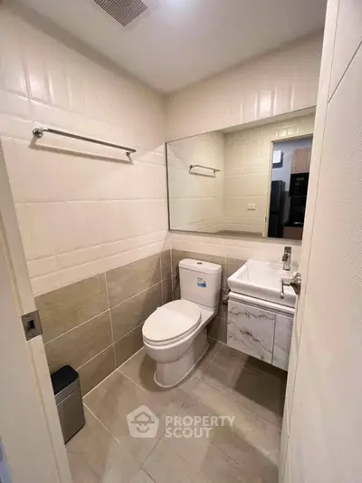 Modern bathroom with sleek fixtures and neutral tiles in a contemporary apartment.