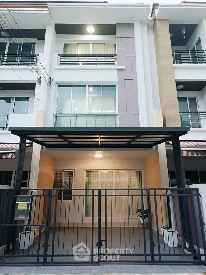 Modern townhouse exterior with gated entrance and sleek architectural design.